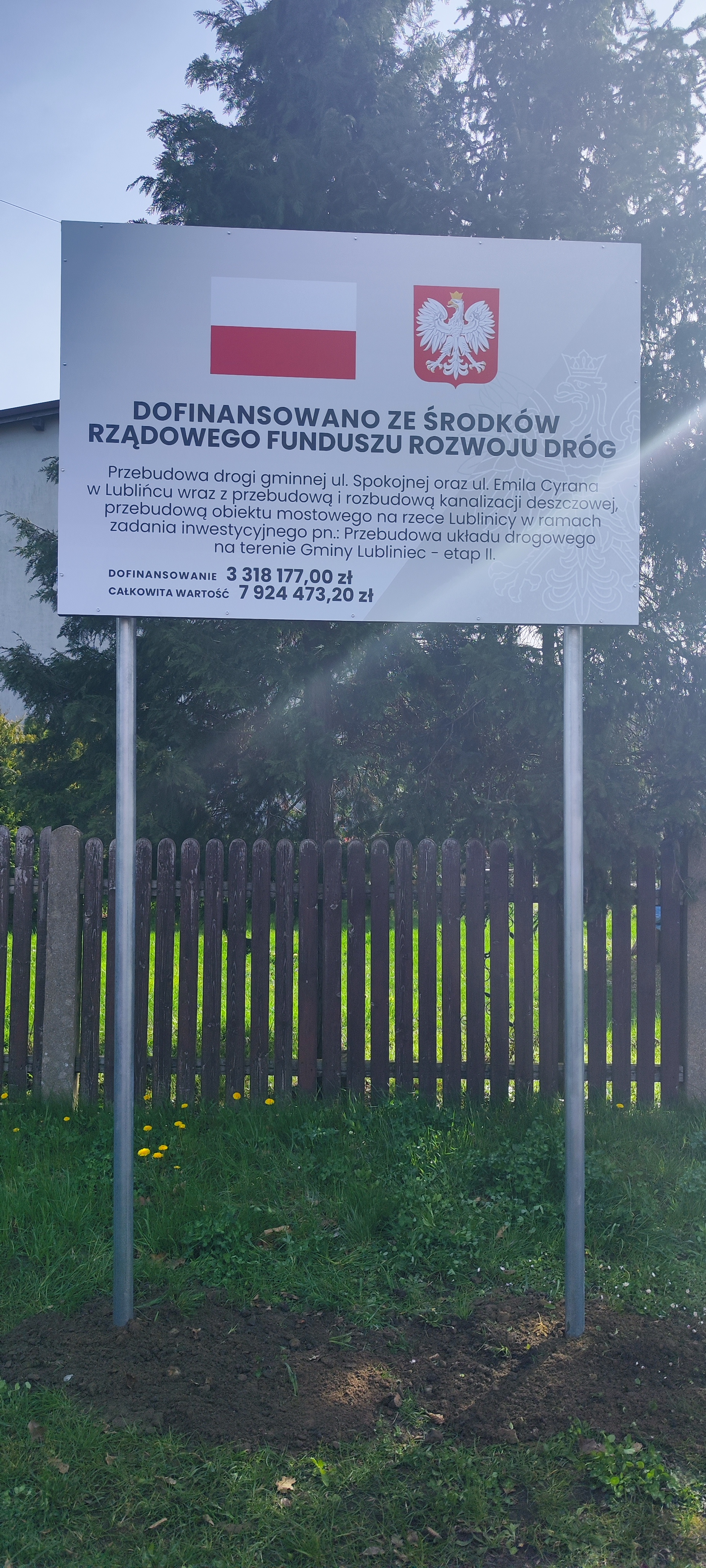zdjęcie przedstawiające tablicę informacyjną o dofinansowaniu budowy drogi
