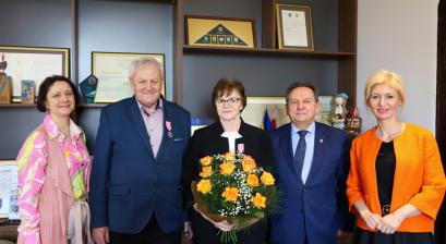 na zdjęciu stoi Urzędniczka - Urzędu Stanu Cywilnego, Państwo Miemcowie Burmistrz E. Maniura oraz Zastępca A. Jonczyk-Drzymała w gabinecie burmistrza. Za nimi widać regały na których stoją dyplomy.
