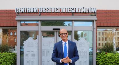 Zastępca Burmistrza Gabriel Podbioł na tle Centrum Obsługi Mieszkańców
