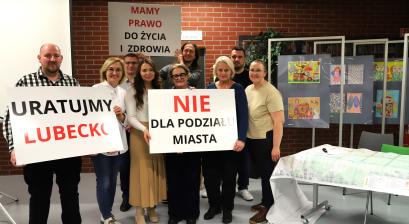 Radni rady miejskie, przedstawiciele Urzędu Miejskiego oraz mieszkańcy trzymają transparenty z hasłami przeciw budowie trasy S11 w wariancie D