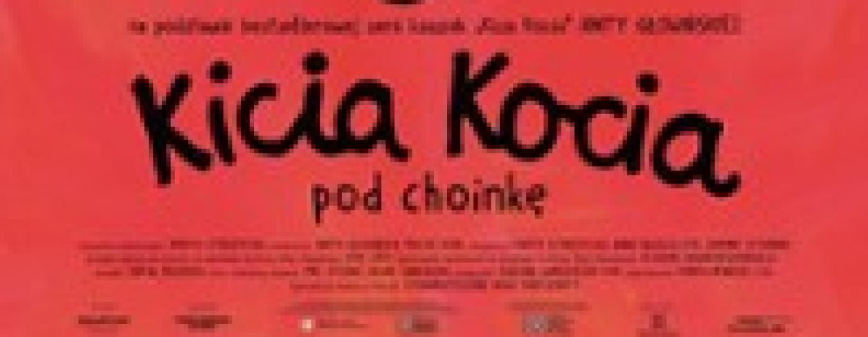 kicia kocia trzyma piernikowego ludka przy choince ozdobionej bombkami
