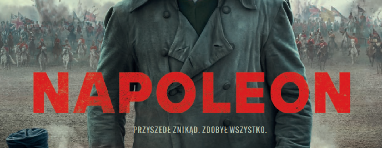 Napoleon w kapelusz na polu walki stoi mniedzy dwoma armatami