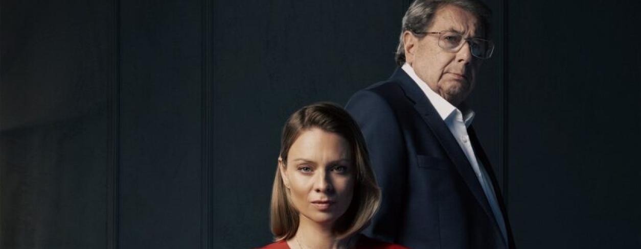 plakat filmowy Różyczka 2 z glówną bohaterką siedzącą w fotelu za nią stoi straszy meżczyzna bohater filmu