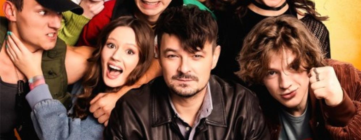 plakat do filmu „PIEP*ZYĆ MICKIEWICZA” z głównym bohaterem nauczycielem polskiego siedzącym na krześle otoczonym przez część klasy wyrzutków sprawiających problemy szkolne