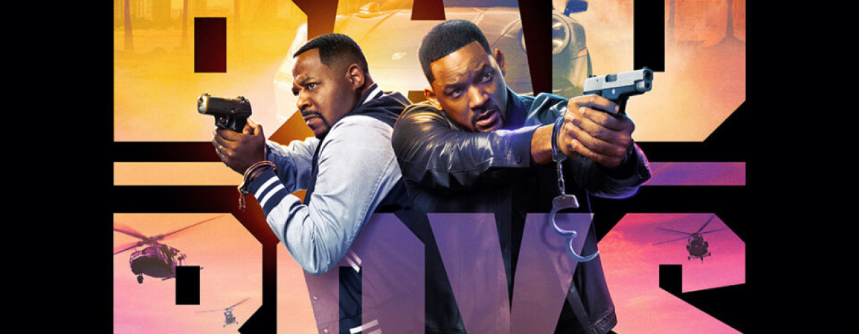 Plakat filmu BAD BOYS: RIDE OR DIE. Dwóch czarnoskórych mężczyzn stoi plecami do siebie i celują z pistoletów.  W tle widać samochody i helikoptery