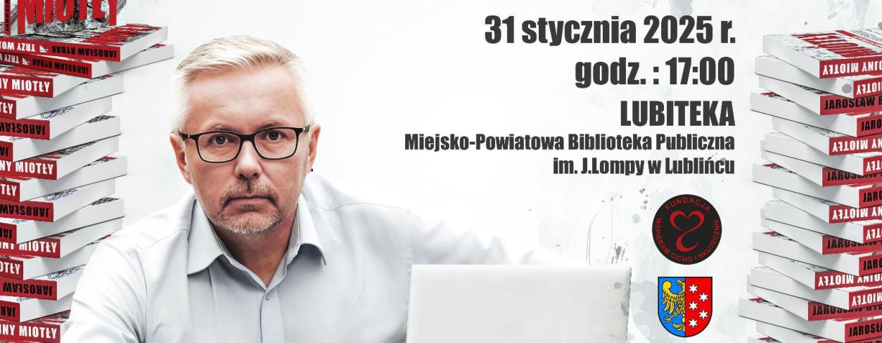 autor Jarosław Rybak  siedzący przy laptopie wokół stosów książek swojego autorstwa