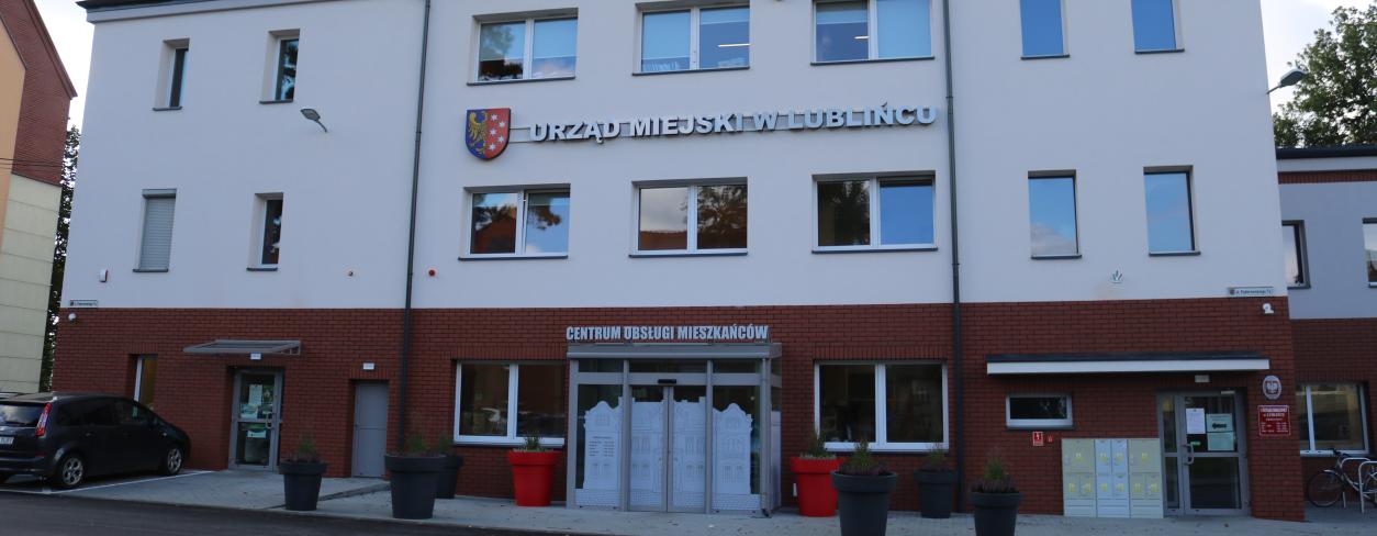 budynek centrum obsługi mieszkańców urzedu miejskiego w Lublińcu front budynku z wiatrołapem i dwoma doniczkami kwietnymi przed wejściem
