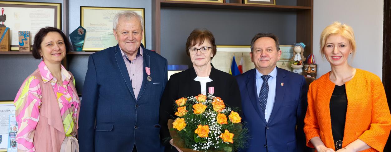 na zdjęciu stoi Urzędniczka - Urzędu Stanu Cywilnego, Państwo Miemcowie Burmistrz E. Maniura oraz Zastępca A. Jonczyk-Drzymała w gabinecie burmistrza. Za nimi widać regały na których stoją dyplomy.