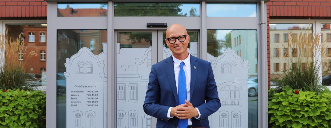 Zastępca Burmistrza Gabriel Podbioł na tle Centrum Obsługi Mieszkańców