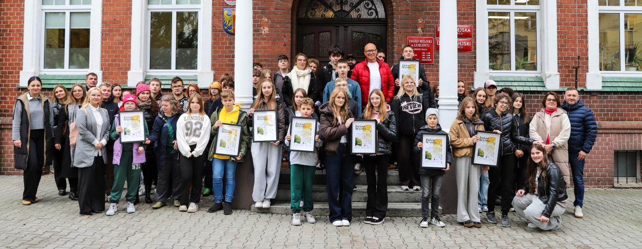 Zdjęcie młodzieży szkół podstawowych i ponadpodstawowych na tle budynku Urzędu Miejskiego