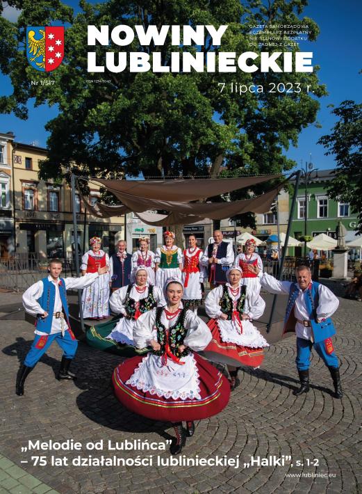 zdjęcie człłonków zespołu halka na lublinieckim rynku, panie w strojach śląskich, 3 panie z baletu tańcą na pierwszym planie za nimi stoja członkowie churu z dwomaprezesem janem Mańką 