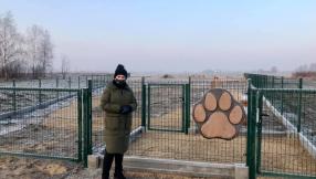 widok na wejście na obiekt psiego wybiegu wraz z pomysłodawczynią projektu stojącą po lewej stronie furtki